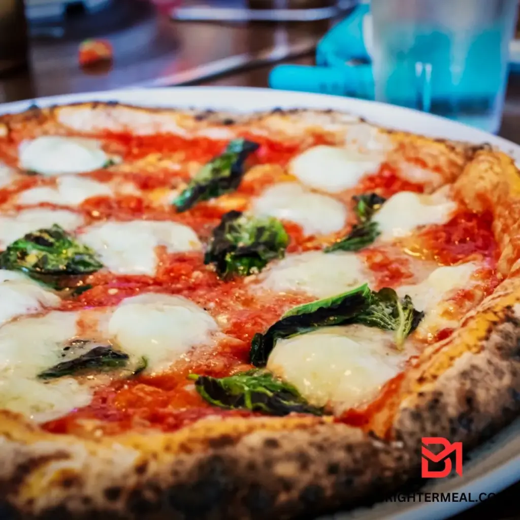 A wooden peel holding a fully assembled pizza, ready to be placed into the oven.